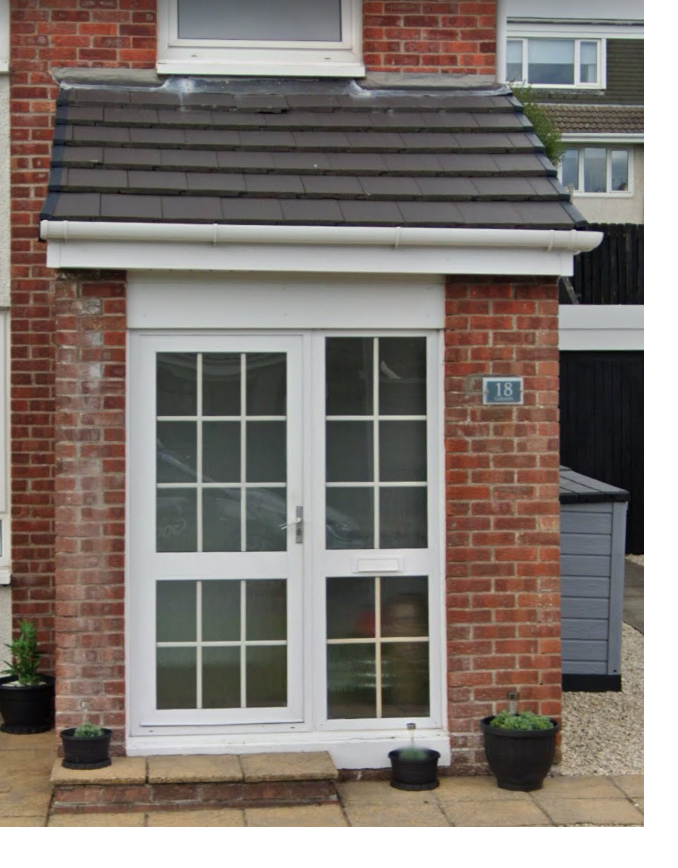 Tired white Georgian bar front door in a brick porch before replacement