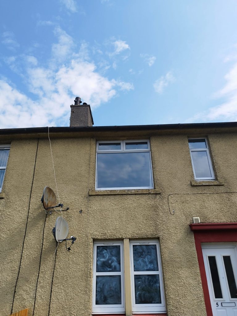 The same upstairs window from the street after new glass was fitted