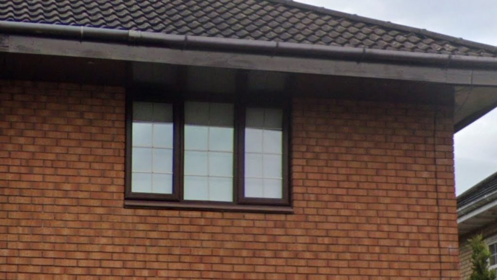 Brown uPVC window with both panes whited out by blown sealed units