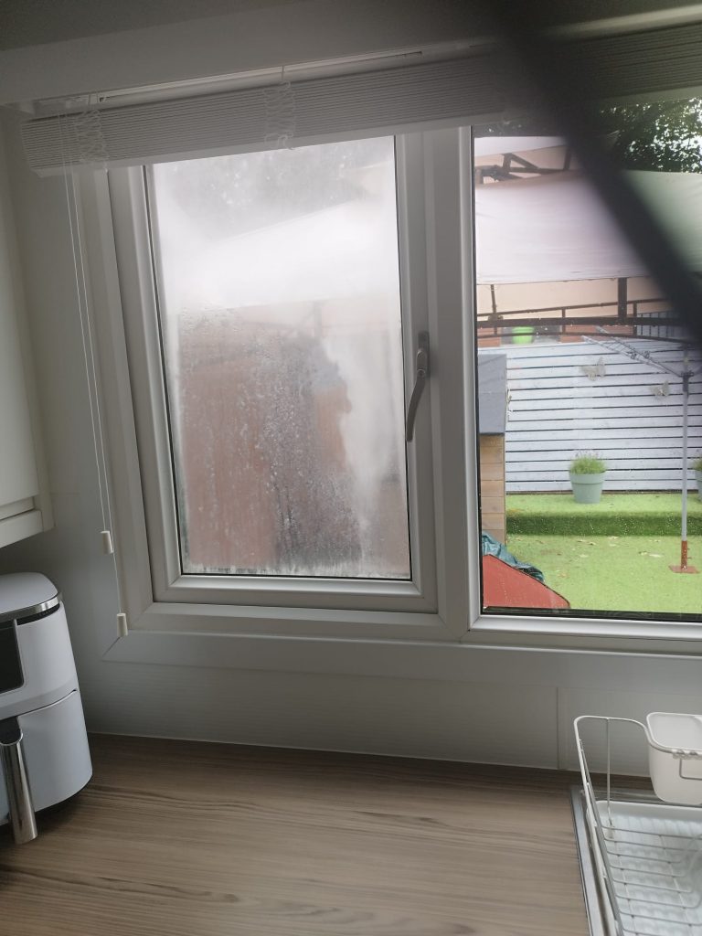 Misted double glazing in a white uPVC window before the sealed unit was replaced
